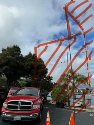Orange story poles outlining the height of the proposed building next to existing homes on Mallard Road