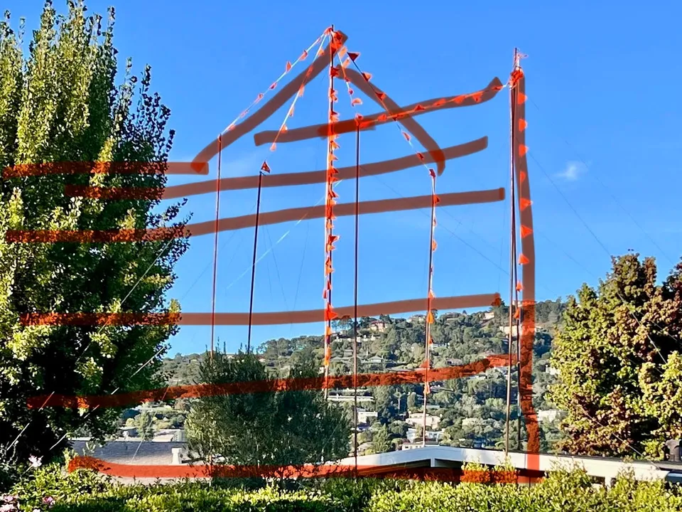 Orange story poles outlining the full length and height of the proposed apartment building on Mallard Road
